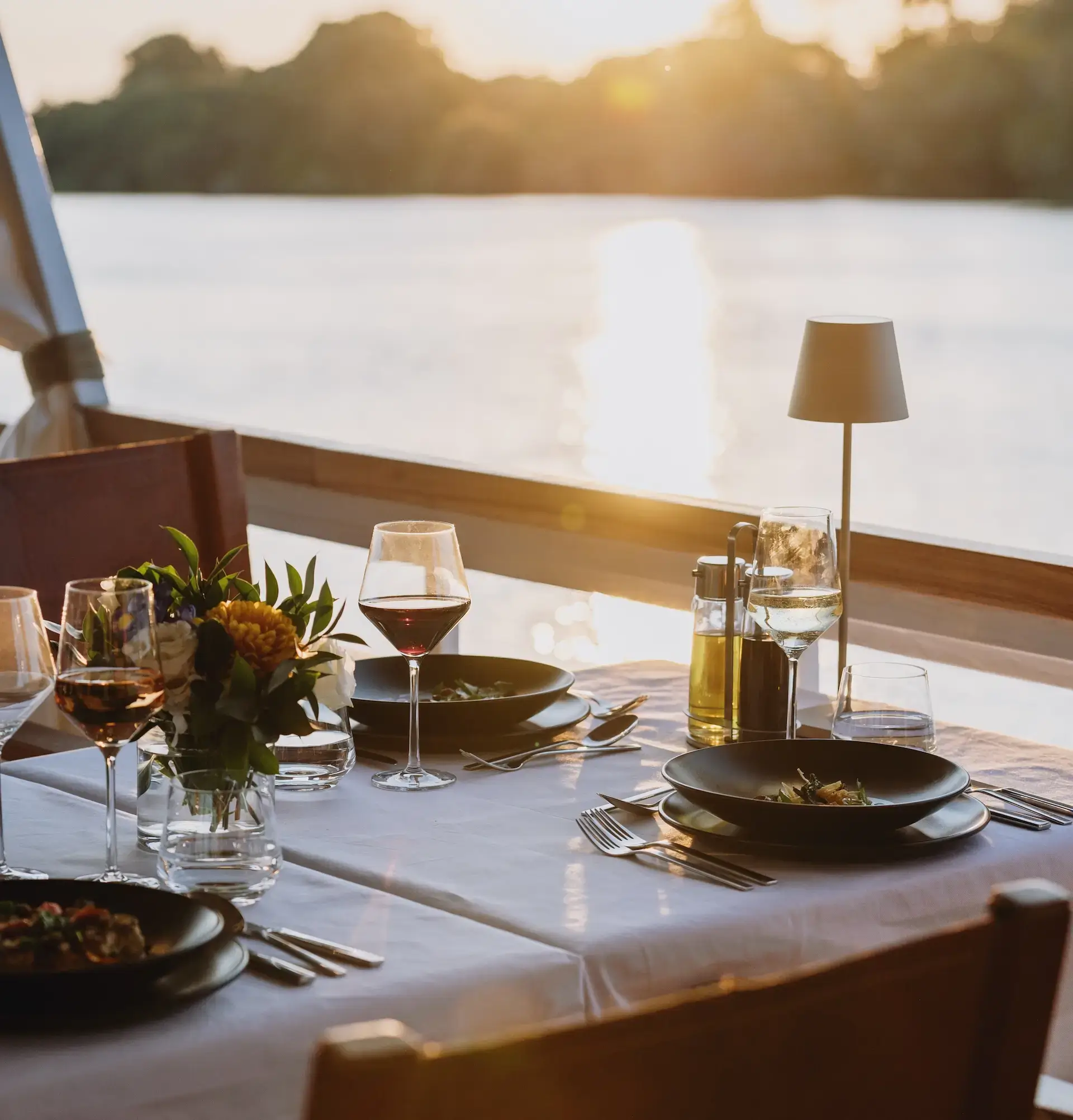 Pure Africa's classic dinner cruise - a table on board the boat with a view of the river. Vic Falls river cruises.