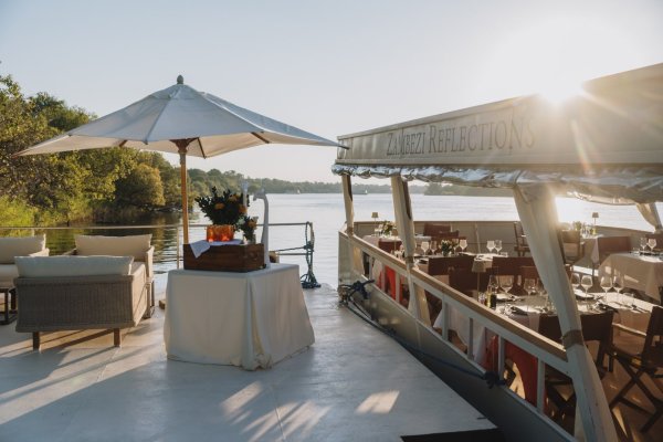 Classic dinner setting on the Zambezi Reflections boat on a sunny day.